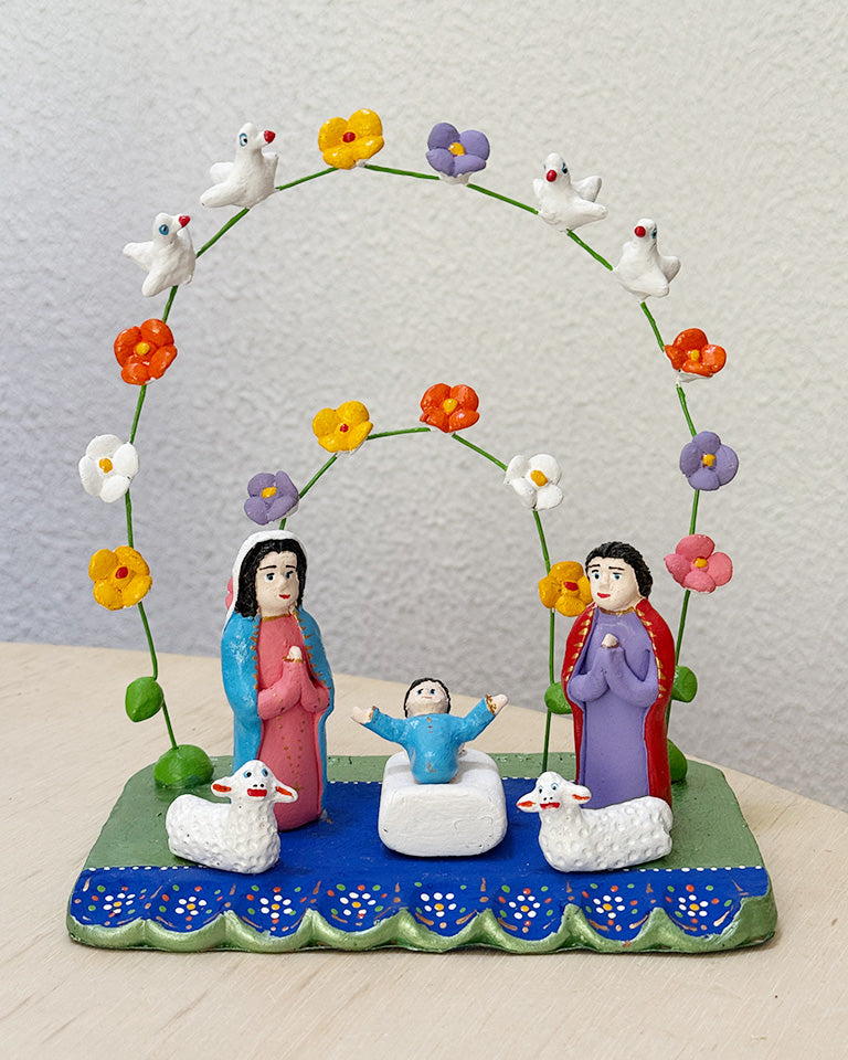 Presépio azul e verde com arcos (aves brancas e flores coloridas)