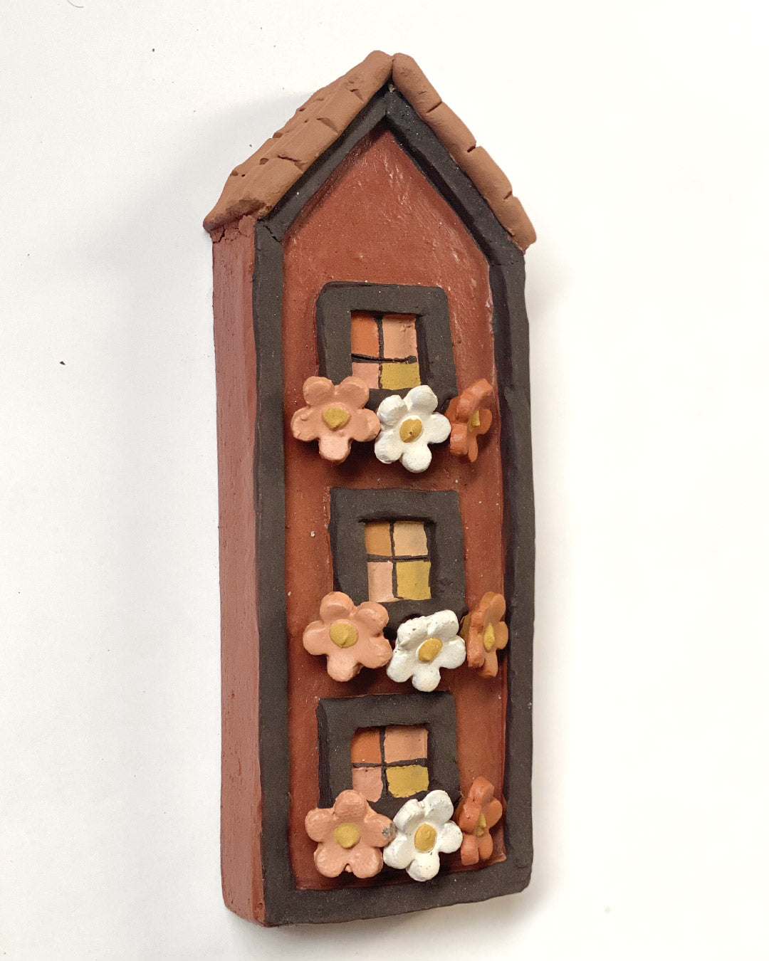 Casa marrom com flores coloridas nas jardineiras (parede)